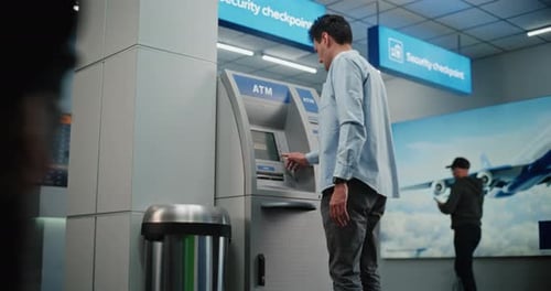 ATM Machine in Airport Terminal Man Entering PIN Code for Money Withdrawal Operation Taking Cash