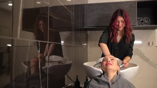 Hairdresser Washing Customer's Hair at Salon