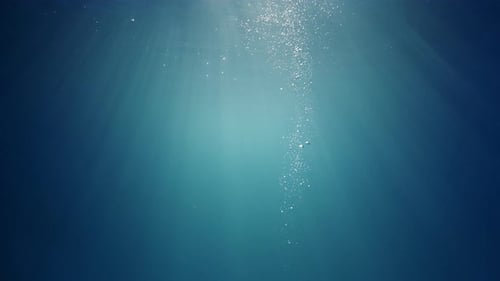 Los rayos del sol brillan a través de las profundas y cristalinas aguas de color azul turquesa que provocan una hermosa