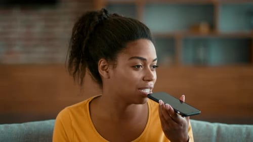 Woman Recording Voice Message on Smartphone Indoors