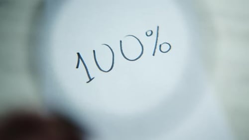 Auf dem Blatt steht "100%", aber es ist verschwommen. Eine Lupe erscheint, wodurch das Bild klarer
wird.