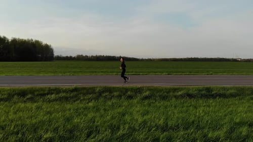 A Young Woman Running Down the Road