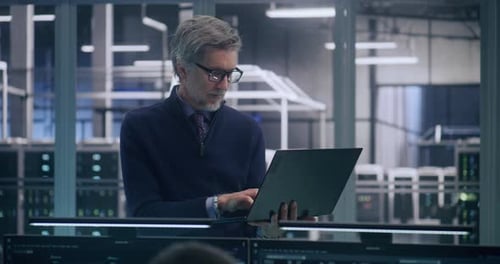 Focused Senior Manager in Formal Business Casual Wear Uses Laptop to Analyze Data