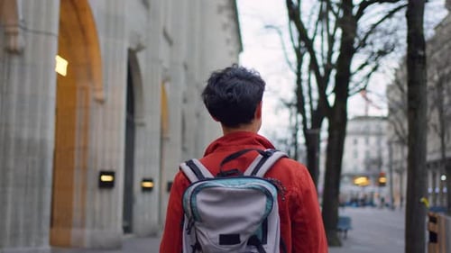 Asian attractive man backpacker walking around beautiful road in city.