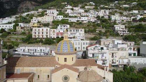 Un
chariot aérien sort d'un magnifique clocher, révélant l'église et le village environnant. Positano, Italie