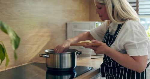 Woman in Beautiful Apron Standing in Modern Kitchen Holding Desk with Tasty Gnocchi Pierogi