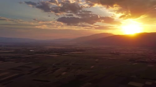 Sunset Over Fields and Mountains