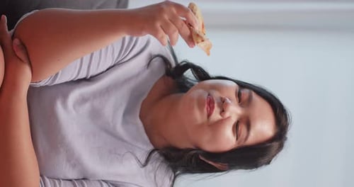 Woman Eating Pizza Slice Indoors, Close Up Vertical
