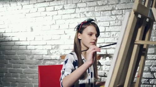 Creative Pensive Painter Child Paints a Colorful Picture on Canvas with Oil Colors in Workshop