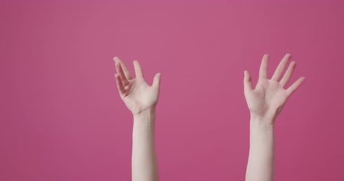 Hands Performing Finger Pointing Against Pink Background