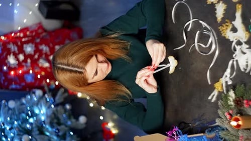 A Caucasian Woman Ties a Ribbon on a Toy in the Shape of a Bird