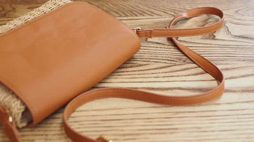 Stylish Tan Purse with Woven Straw Body on Wood