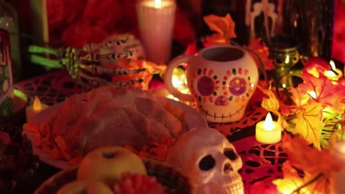 Mesa del Día de Muertos con ofrendas de comida y calaveras de azúcar, establecido