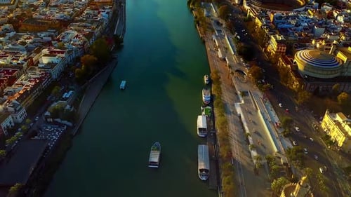 Aerial shot looking down at the Guadalquivir River, Seville Spain and tilting up to the sunset on th