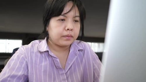 Young adult woman working on laptop computer in cafe
