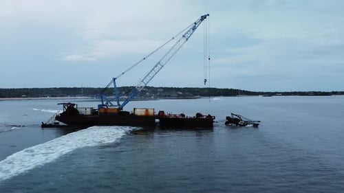 Shipwreck of container vessel sits decaying off island coast. Aerial