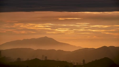 At dusk, the sun breaks through the clouds and moves toward the mountains.