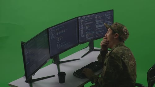 Tired Asian Man Soldier Yawning While Write Code With Multiple Computer Screens In Green Screen