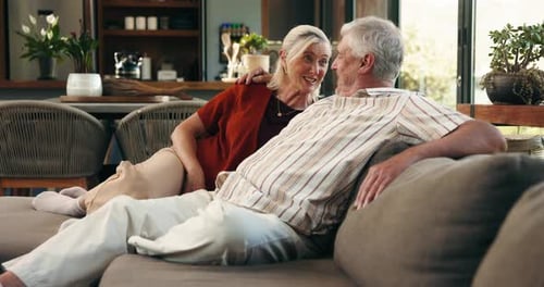 Senior couple, talk and laugh on couch for bonding, love and care with funny story in lounge