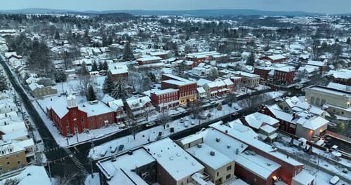 Aerial establishing shot of small town in USA covered in snow. Blue hour light in America.