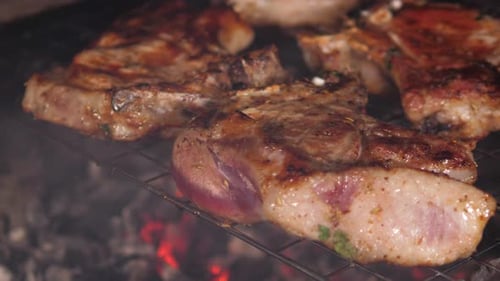 Pork Chops Sizzle on Grill with Hot Coals