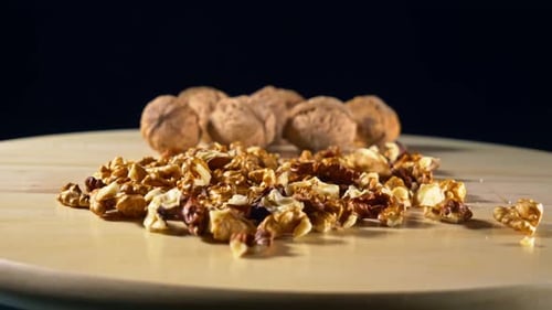 Walnut Pieces and Whole Walnuts on Wooden Surface