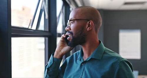 Smiling Man Talking on Cell Phone by Office Window