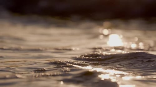 Bei Sonnenuntergang rauschen Meereswellen am Strand. Surfing in Zeitlupe, Meer, Wildwasserwelle.