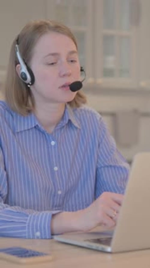 Young Woman with Headset Talking with Customers Online in Call Center, vertical video