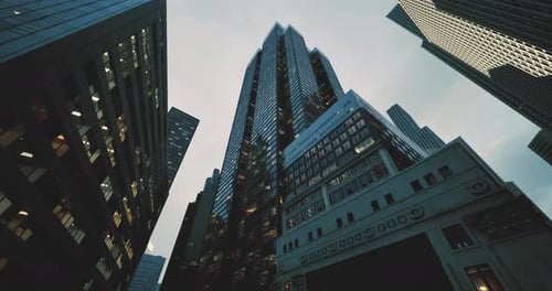 Alto rascacielos rodeado de edificios de la ciudad bajo un cielo nublado