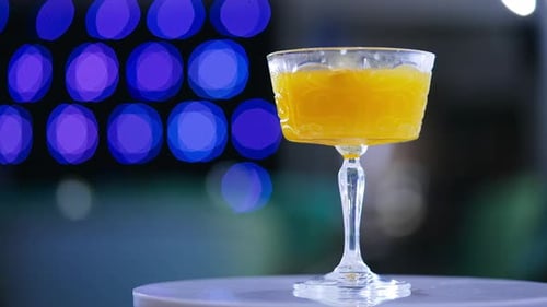 Golden Cocktail on a Table with Bokeh Lights