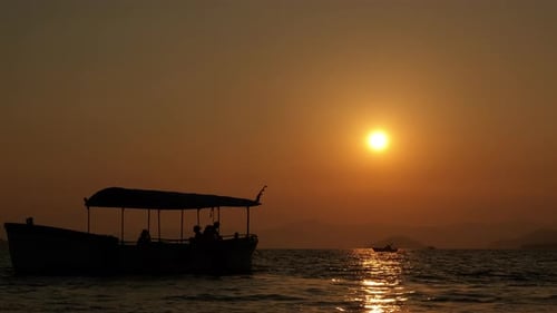 Sunset Over Ocean with Silhouetted Boat