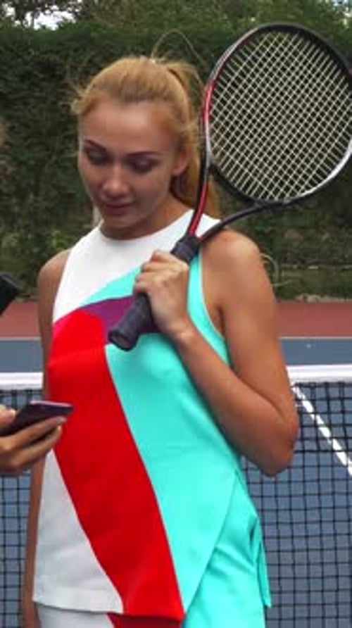 Two Young Women Using Phone on Tennis Court