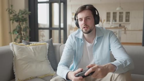 Man Playing Video Game on Couch with Headphones
