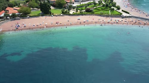 Aerial View of a Beach with People Vacationing on the Mediterranean Coast with Clear Blue Water
