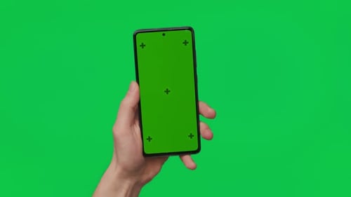 Male Hand Holding a Smartphone with Vertical Green Chroma Key Screen Isolated on Green Mobile Phone