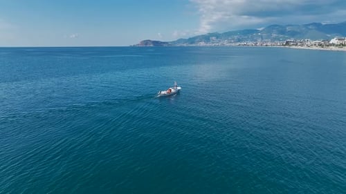 Aerial Video Aerial View of a Fishing Boat in the Distance with City and Sky As Backdrops