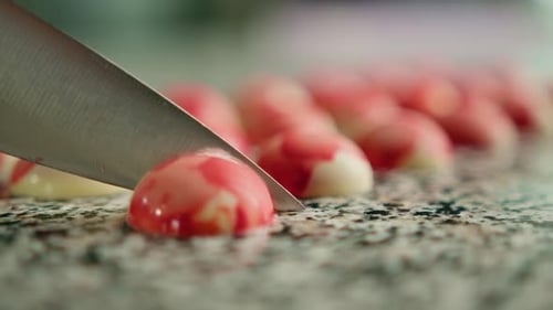 Knife slicing a red and white candy dome