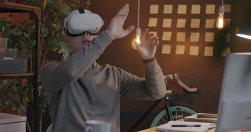 Young Businessman Wearing Virtual Reality Glasses Playing Game Relaxing During Break in Office at