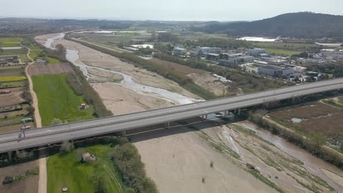 Aerial circling shot of Spanish highway over Tordera River