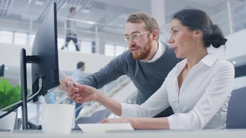 Colleagues Working Together on Computer in Modern Office