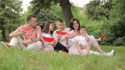 Family Enjoys Watermelon Picnic in Green Park