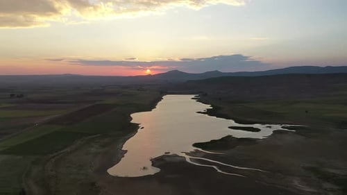 Vue aérienne du lac asséché et des terres agricoles au coucher du soleil
