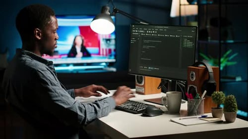 Man Works at Computer in Home Office at Night