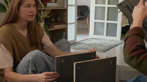 Couple Placing on Side Panel with Fixtures while Assembling Cabinet