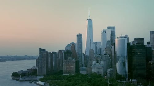 Aerial shot of New York skyscrapers and financial district buildings at pink sunset.
