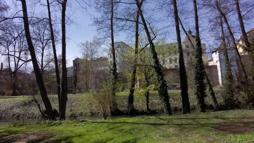 Olomouc city park with river and trees, views of the city walls and historic buildings on a spring m