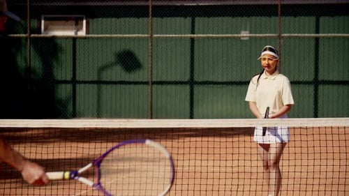 A Man Coach with a Ward Girl Conduct a Joint Training Tennis Set at Light Intensity The Serving and