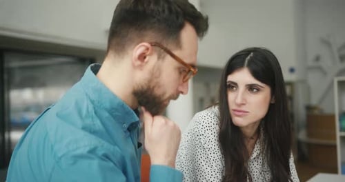 Une équipe préoccupée discute du projet dans la bibliothèque