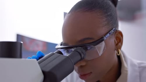 Female Scientist Using Microscope in Laboratory